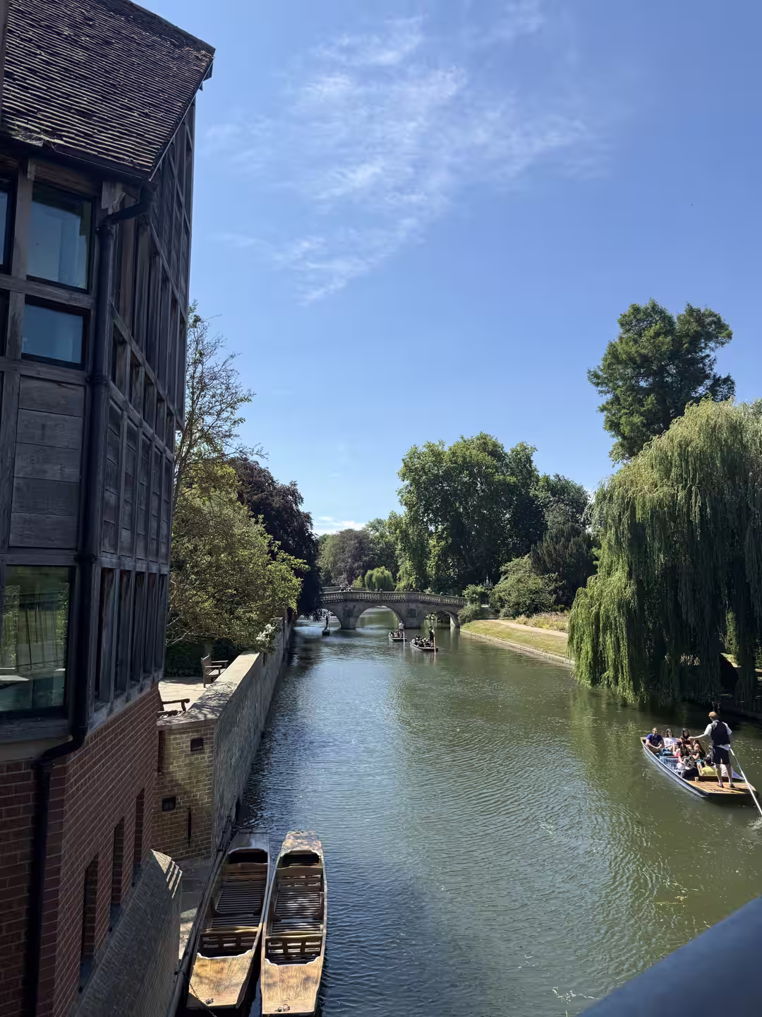Wooden punts moored by a boathouse on the River Cam, Cambridge